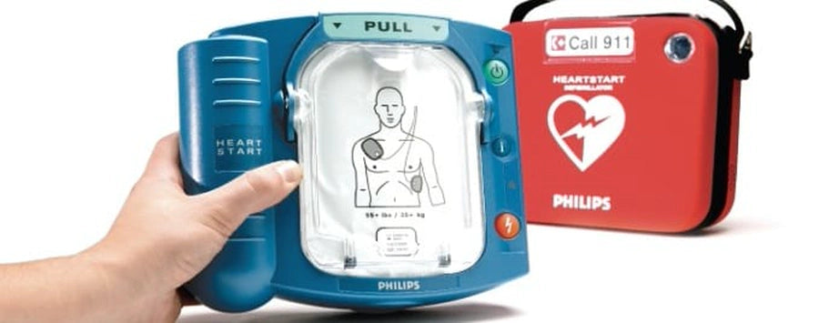 Philips HeartStart AED device with its carrying case in the background