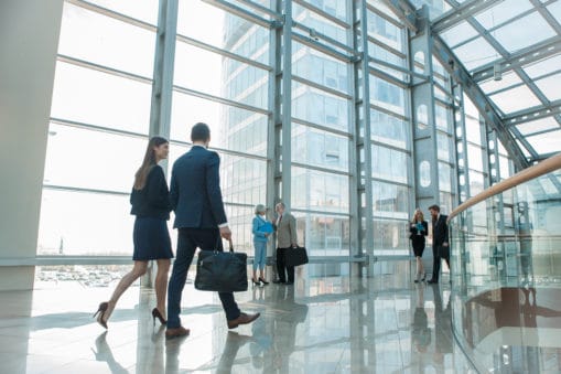 modern office building with groups of coworkers conversing