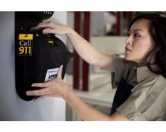 woman putting AED in wall mounted cabinet