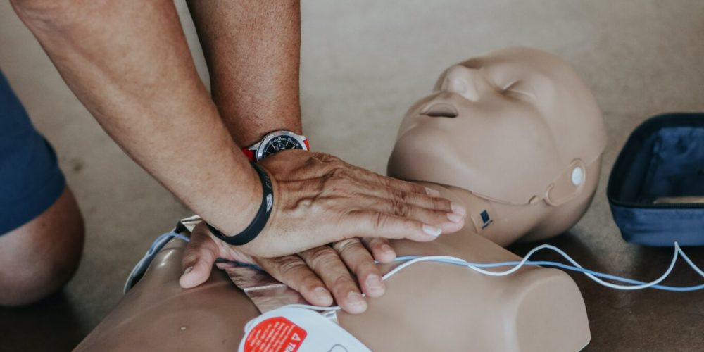 man pushing on cpr manikin