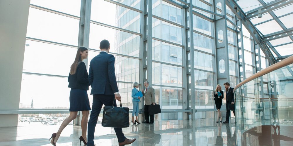 modern office building with groups of coworkers conversing